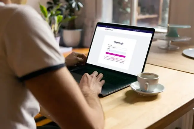 A person uses the Checks Direct website on a laptop.